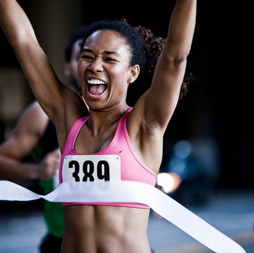 Runner crossing the finish line a person in a pink shirt