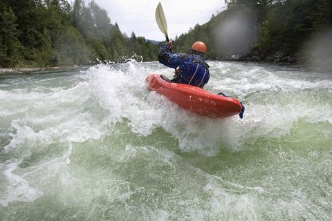 man kayaking in river