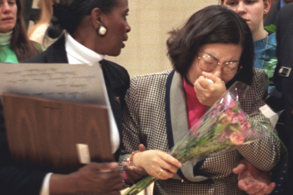 youn kim, mother of hae min lee, is escorted from her daughter's memorial service by guidance counselor gwen kellam, on march 11, 1999, in baltimore, maryland