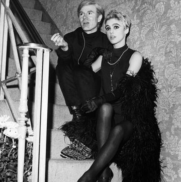 artist andy warhol and edie sedgwick, who wears a black feather boa, sit on a staircase chatting undated photo photo by john springer collectioncorbiscorbis via getty images