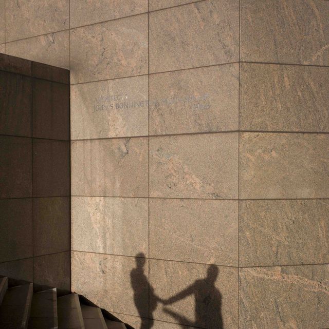 the shadows of an anonymous couple holding hands are seen on a wall in southwark, on the south side of london bridge there is an obvious relationship between the two, a liaison or affair seen as silhouetted figures, we see their shape and form against the constructed modern wall of an office development on the southern side of london bridge in the borough of southwark