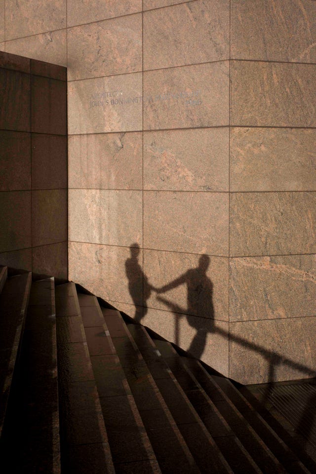 the shadows of an anonymous couple holding hands are seen on a wall in southwark, on the south side of london bridge there is an obvious relationship between the two, a liaison or affair seen as silhouetted figures, we see their shape and form against the constructed modern wall of an office development on the southern side of london bridge in the borough of southwark