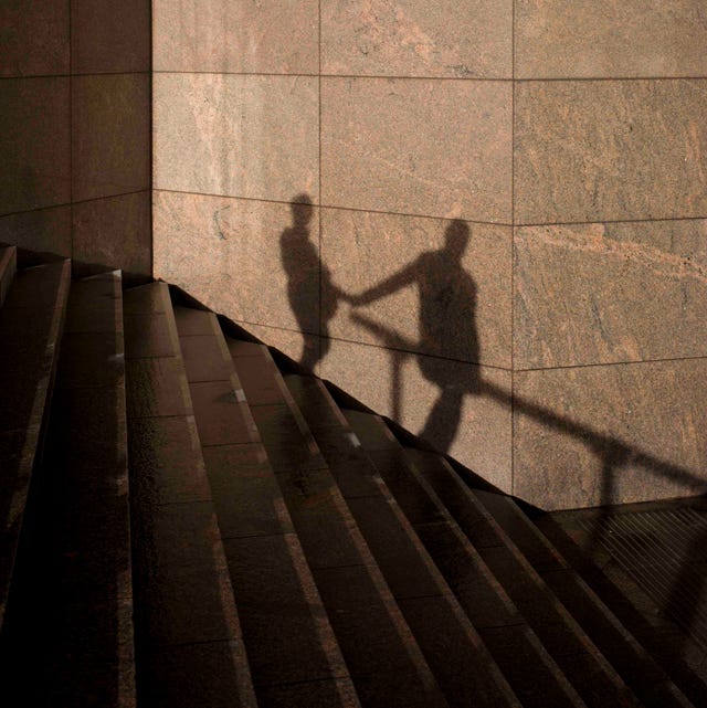 the shadows of an anonymous couple holding hands are seen on a wall in southwark, on the south side of london bridge there is an obvious relationship between the two, a liaison or affair seen as silhouetted figures, we see their shape and form against the constructed modern wall of an office development on the southern side of london bridge in the borough of southwark