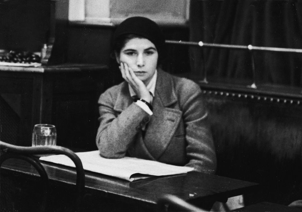 una joven mujer bohemia francesa espera en una mesa en el cafe de la rotonda de paris años 30