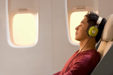 a person wearing headphones and sitting in an airplane