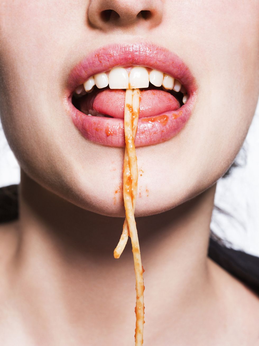 Spaghetti hanging from beauty model's mouth