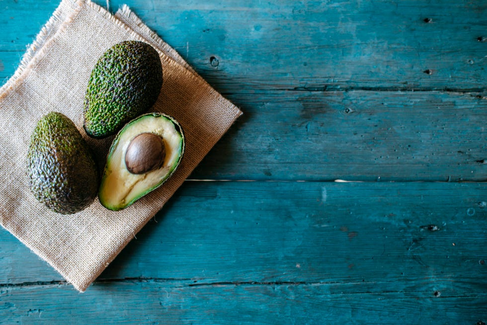 avocados whole on old wooden background with copyspace