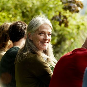 portrait of smiling senior woman sitting with family at park