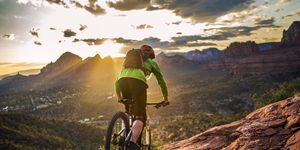 a male mountain biker rides the famous hangover trail above sedona, arizona as the late afternoon sun shines through sedona is famous for its slickrock trails, with this trail being one of its more iconic routes