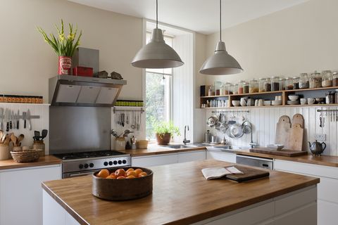 spacious kitchen with open shelving and solid oak work surfaces the pendant lights and units are both by ikea