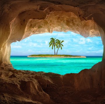 an old indian cave located on a remoteturks and caicos island beautiful caribbean sea glowing and warm sunlight bathing some remote palm trees on a deserted island