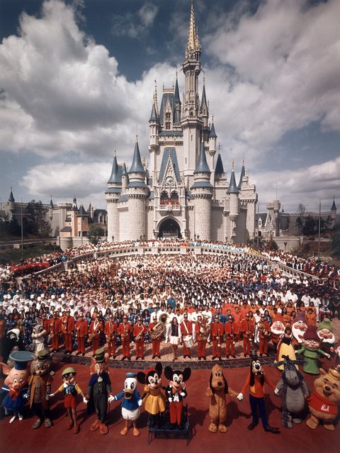 Walt Disney characters and park staff posing en ma