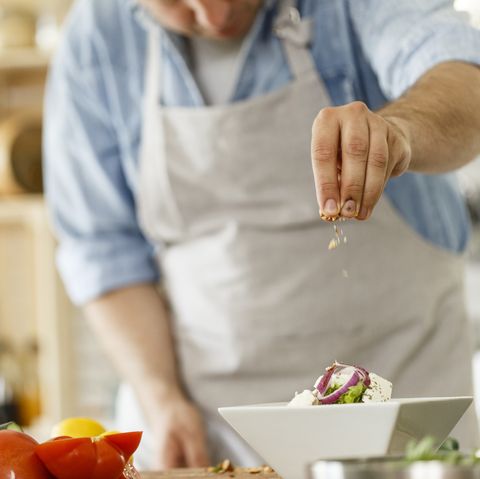 Chef decorating a plate with healthy salad