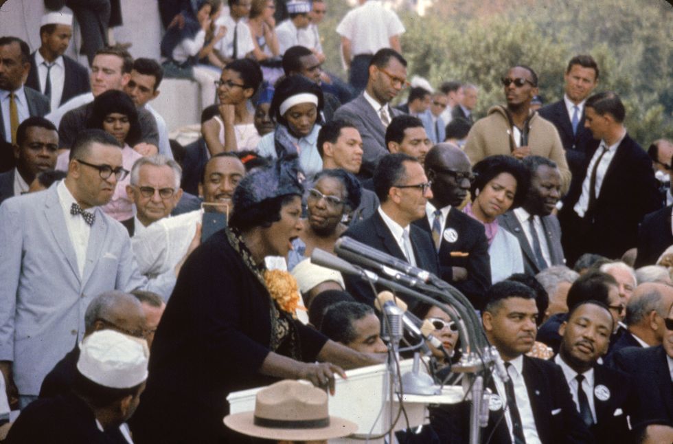 Mahalia Jackson sings at the March on Washington on the steps of the Lincoln Memorial, Washington, DC, on August 28, 1963. Sitting at lower right is civil rights leader Martin Luther King Jr.
