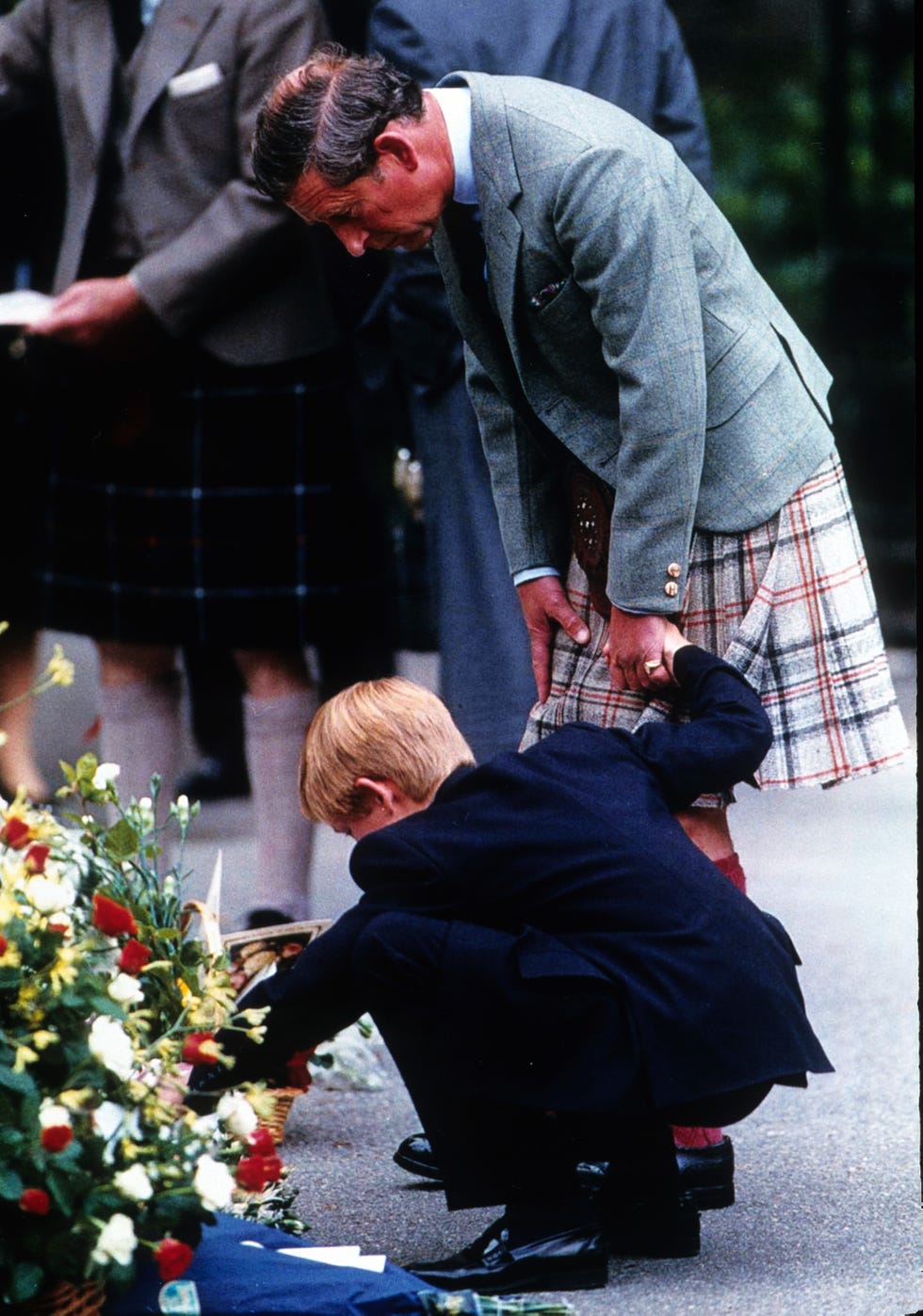 prince charles, prince of wales, holds the hand of prince harry as they view bouquets of flowers left in memory of diana, princess of wales