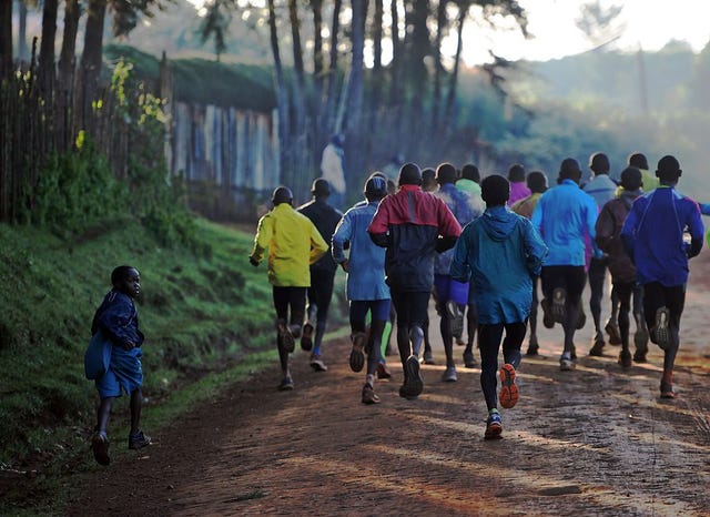 a young boy runs on his way to school alongside a group of elite runners, some of them members of kenyas national team for the rio2016 olympics, during a morning workout at kaptagat in eldoret town, aproximately 350 km north of the capital nairobi, on june 9, 2016 afp tony karumba photo credit should read tony karumbaafp via getty images