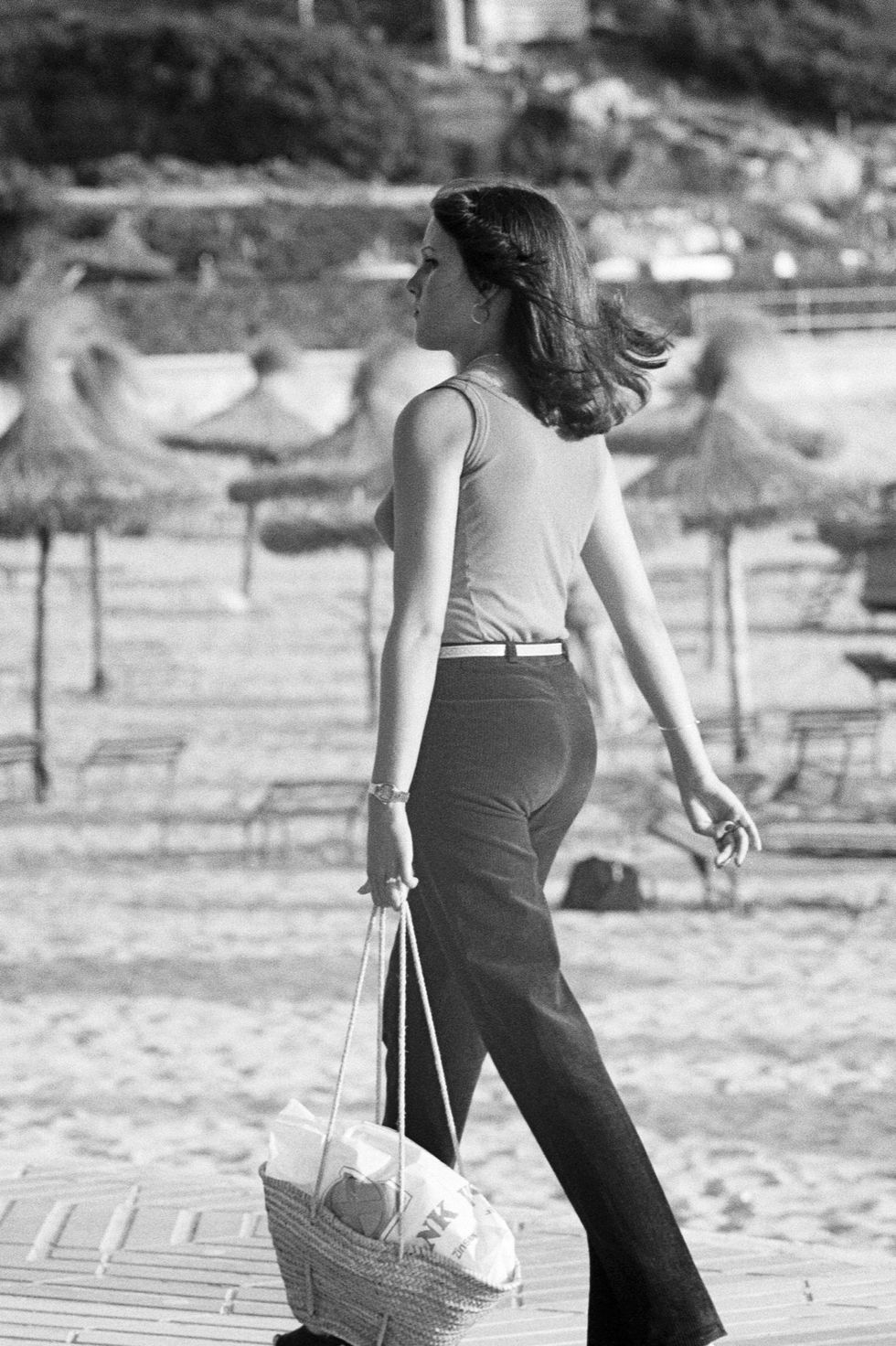 A trendy young woman carrying a Louis Vuitton (LV) handbag walks