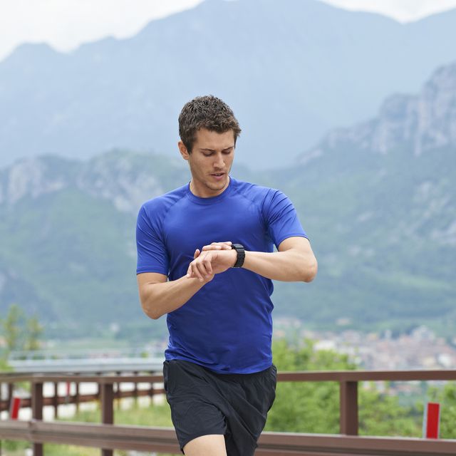 man, blue shirt, running and wachting his watch