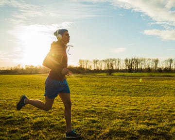 germany, mannheim, young man jogging in meadow