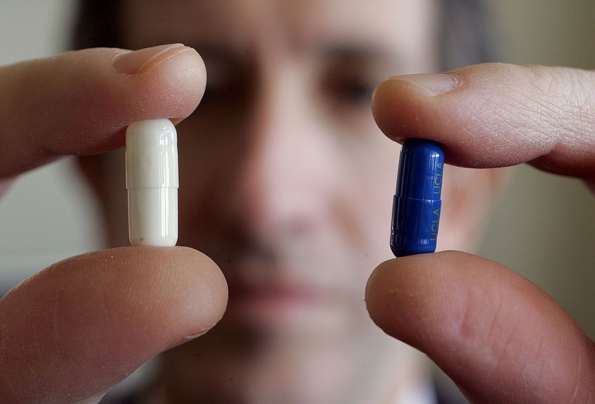 Een psychiater laat twee pillen zien de ene bevat een medisch werkzame stof de andere is een placebo