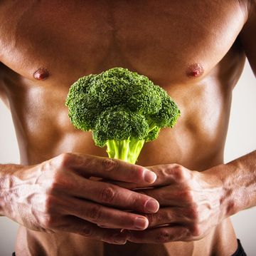 muscular caucasian athlete holding broccoli