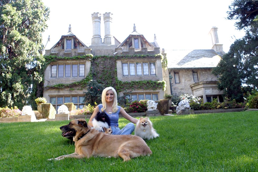 Holly Madison, one of the stars of The Girls Next Door, poses in front of the Playboy Mansion. ​