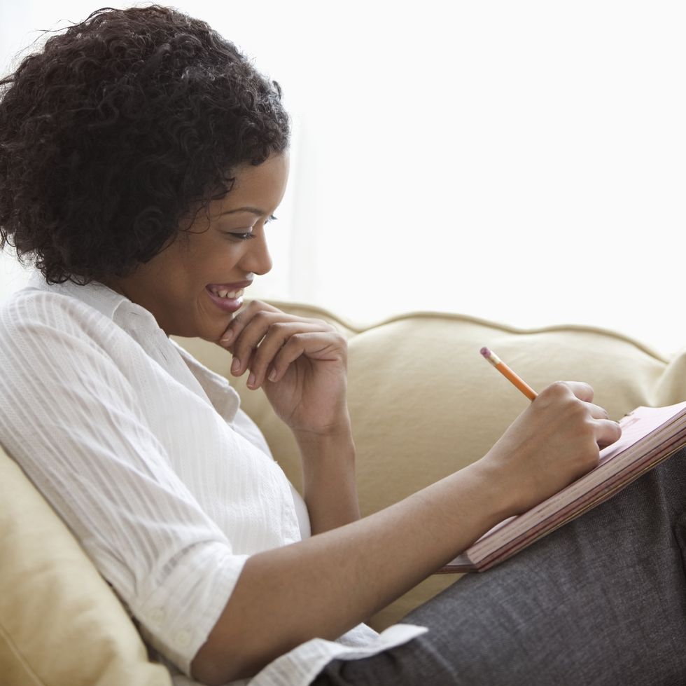 woman sitting on sofa with notepad on her lap
