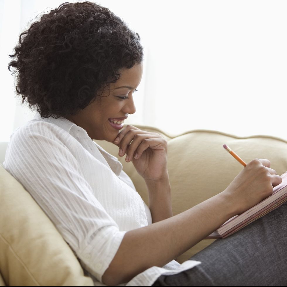 woman sitting on sofa with notepad on her lap