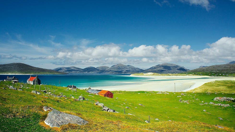 the sands of luskentyre viewed from the hill above seilebost on the isle of harristhe isle of taransey can be seen on the left and the hills of harris in the distancea red roofed cottage,abandoned some years ago sits on the hillside
