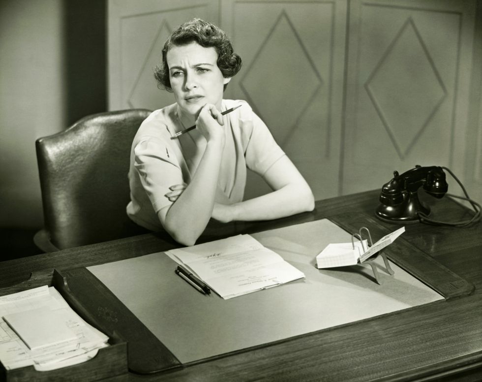 mujer preocupada sentada en su puesto de trabajo en la oficina ellees
