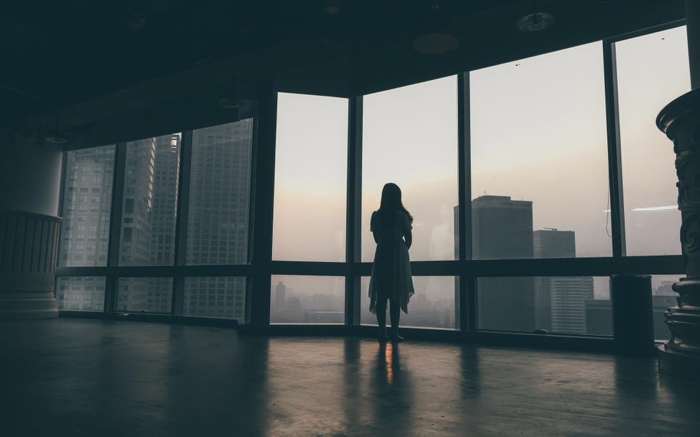 woman looking out the window at city