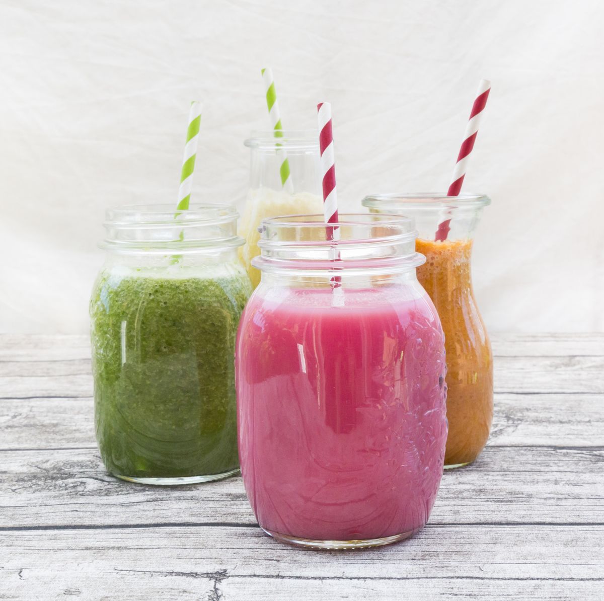four glasses of different smoothies