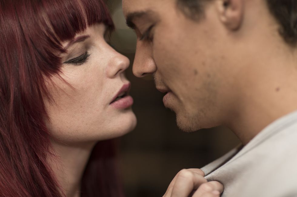 Young woman seducing young man in a bar, close-up