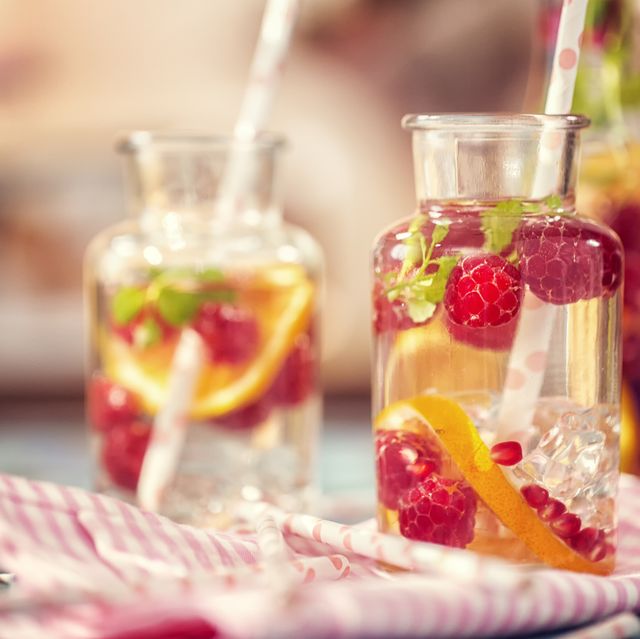 infused water with fresh raspberries, lemon, pomegranate and mint served in a glass jar