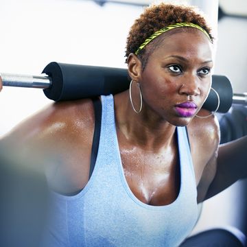 woman lifting weights while working out at the gym