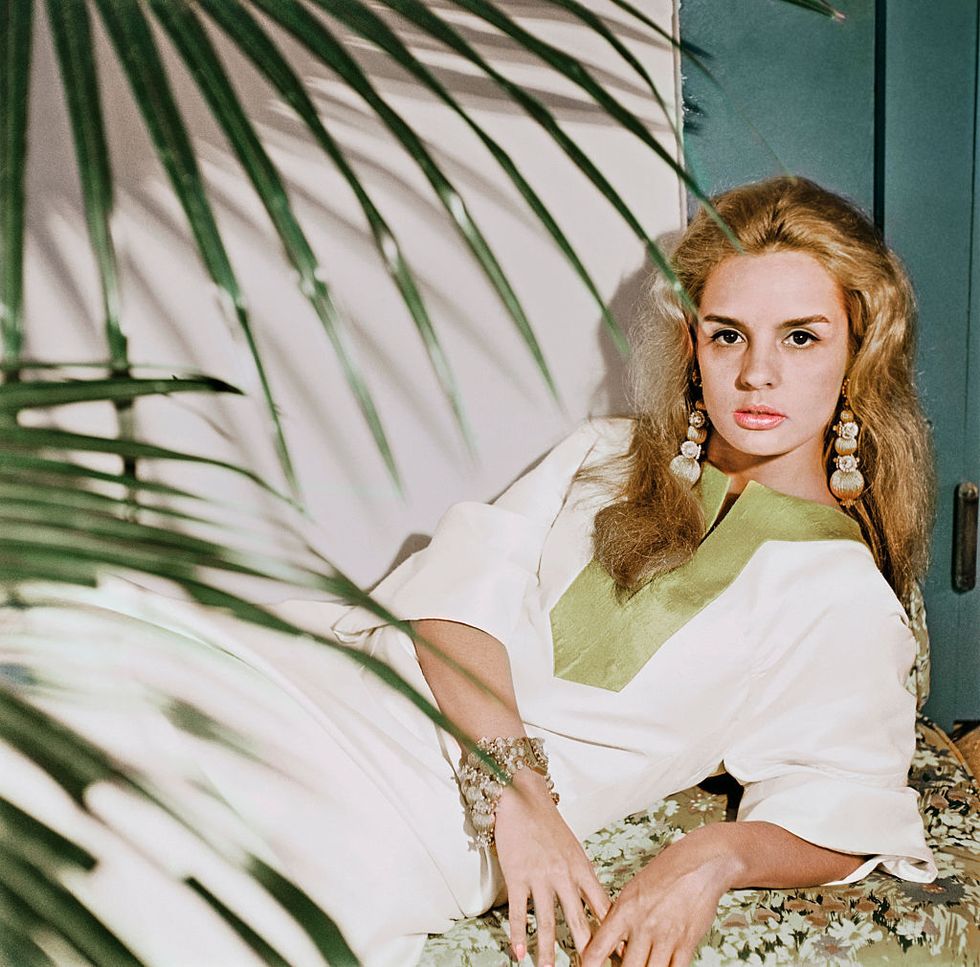carolina herrera reclines wearing a caftan with palm fronds around her photo by horst p horstcondé nast via getty images
