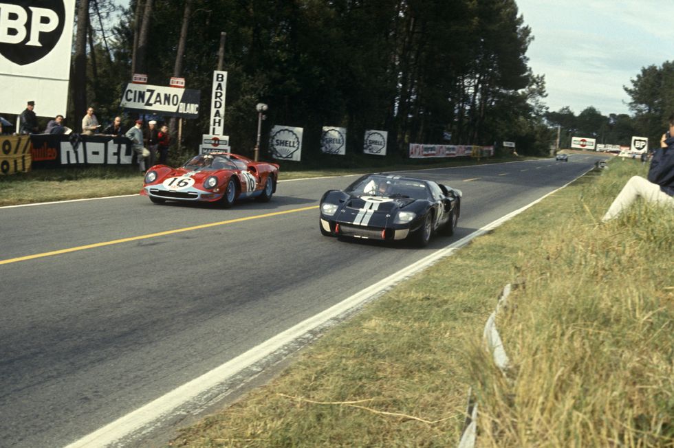 (L-R) Richard Attwood and David Piper driving a Ferrari 365 P2 Spyder (No. 16) and Bruce McLaren and Chris Amon driving a Ford Mk II (No. 2) during Le Mans on June 19, 1966
