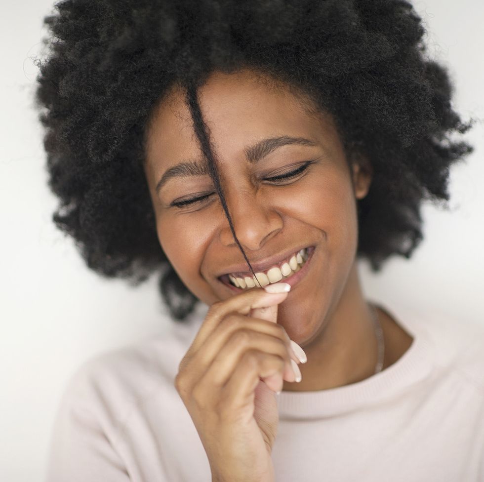 smiling black woman playing with hair