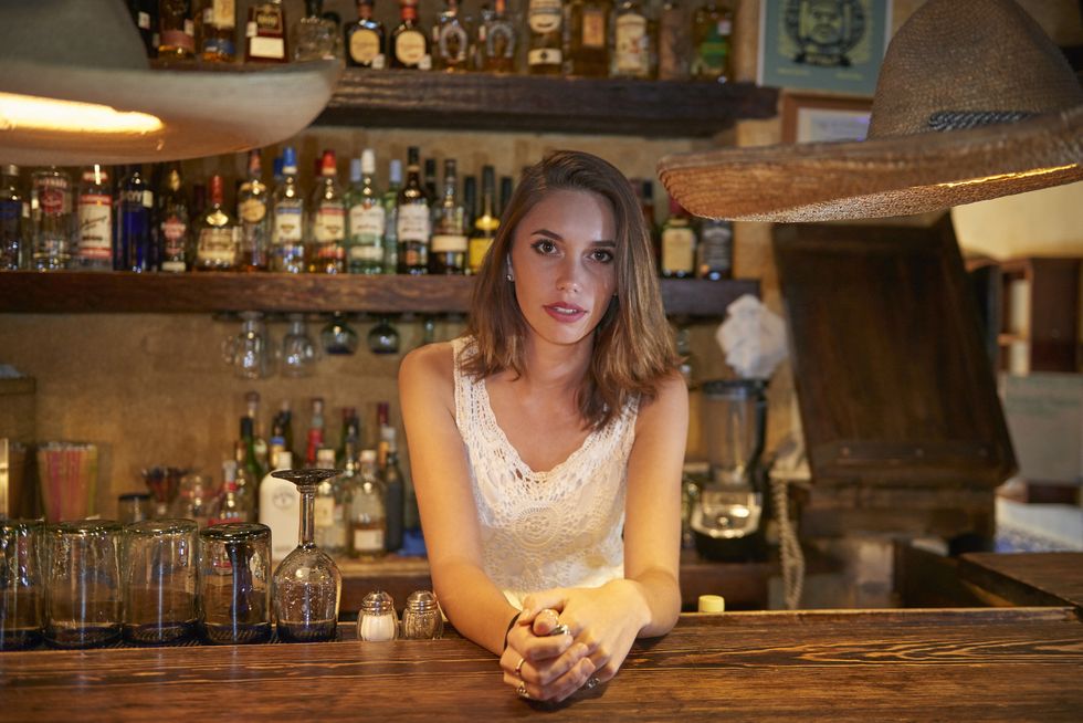 Bartender leaning on bar in restaurant
