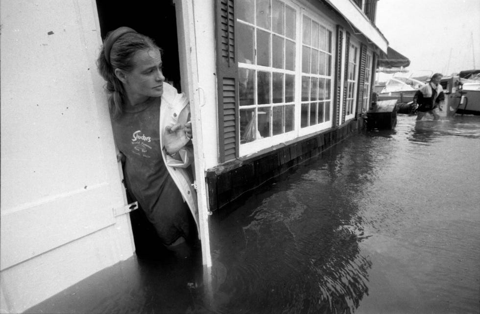 In Woods Hole Massachusetts bekijkt een werknemer de overstromingen die zijn veroorzaakt door hurricane Bob Vr Henri was Bob de laatste tropische storm die in New Engeland aan land kwam in augustus 1991