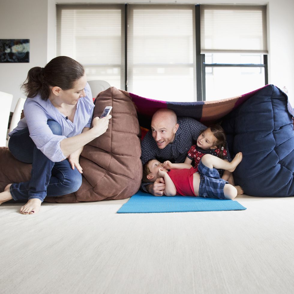 family playing in pillow fort