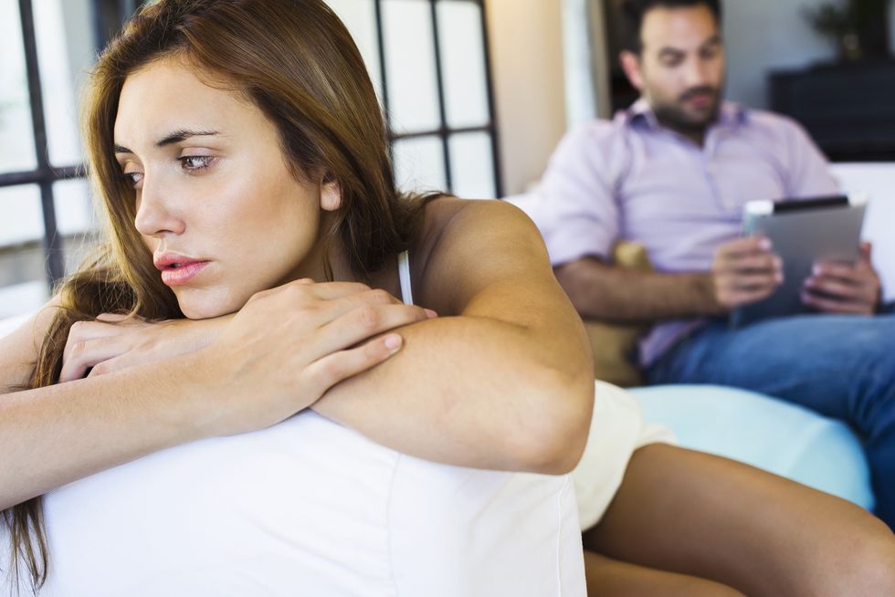 Woman displeased by boyfriend on digital tablet