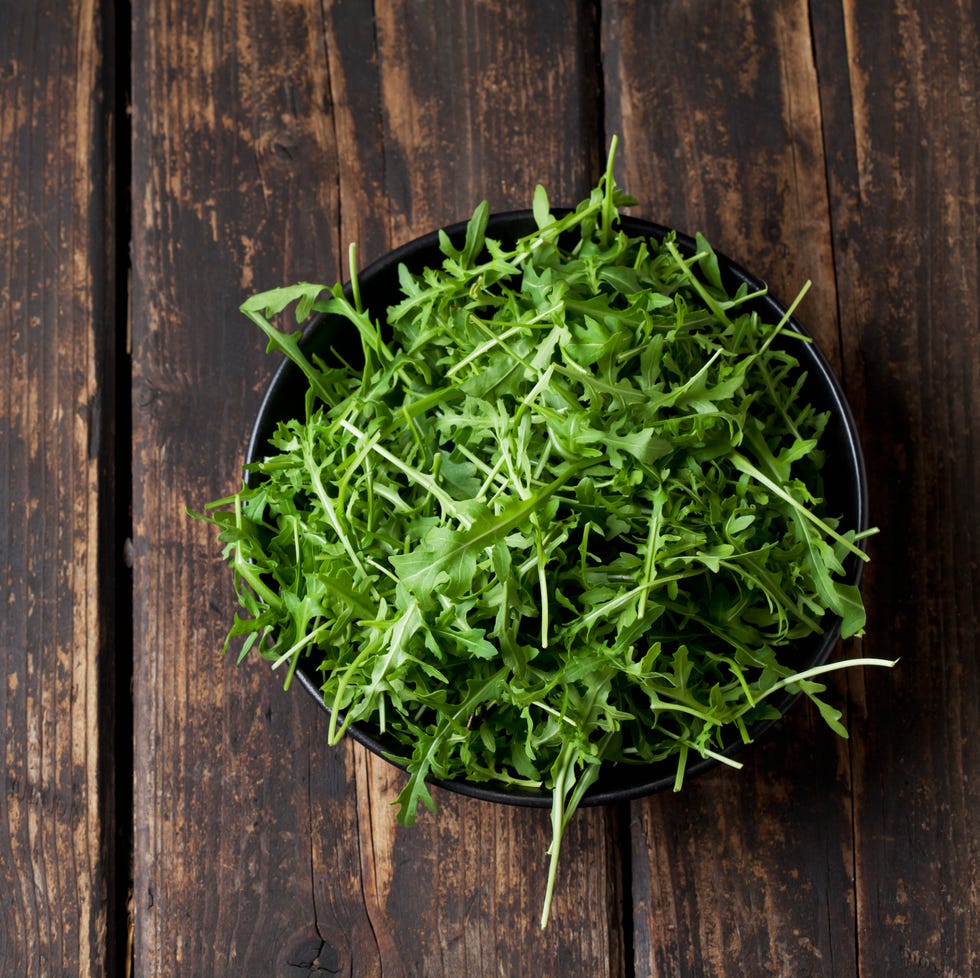 Bowl of rocket on dark wood arugula