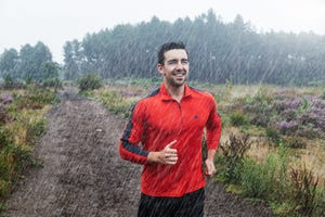 hombre corriendo bajo la lluvia con sudadera roja