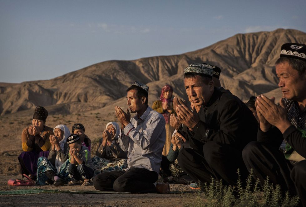 turpan, china   september 12  china out a uyghur family pray at the grave of a loved one on the morning of the corban festival on september 12, 2016 at a local shrine and cemetery in turpan county, in the far western xinjiang province, china the corban festival, known to muslims worldwide as eid al adha or feast of the sacrifice, is celebrated by ethnic uyghurs across xinjiang, the far western region of china bordering central asia that is home to roughly half of the countrys 23 million muslims the festival, considered the most important of the year, involves religious rites and visits to the graves of relatives, as well as sharing meals with family although islam is a recognized religion in the constitution of officially atheist china, ethnic uyghurs are subjected to restrictions on religious and cultural practices that are imposed by chinas communist party ethnic tensions have fueled violence that chinese authorities point to as justification for the restrictions  photo by kevin frayergetty images