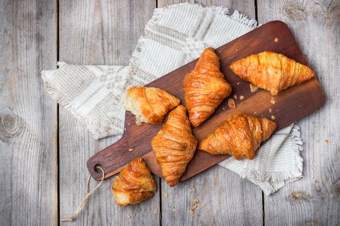 Fresh croissants for breakfast on cutting board rustic table