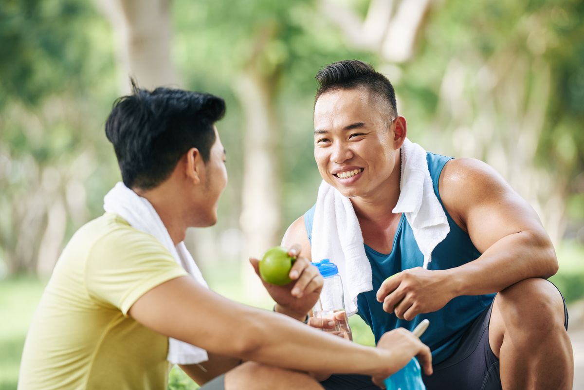 vietnamese sportsmen having apples and water after training