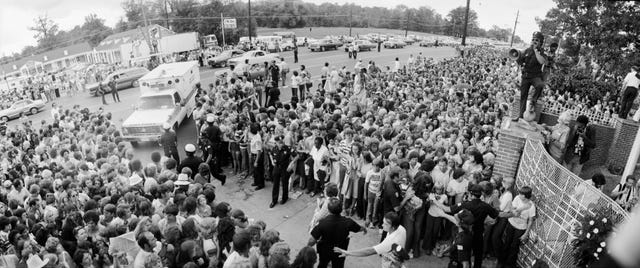 a crowd gathers outside the gates of graceland for the funeral of elvis presley