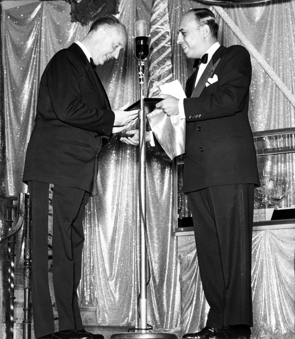 christian dior l, noted paris fashion designer, is shown as he received the ‚Äòdistinguished service in the field of fashion award‚Äô from stanley marcus, of the nieman marcus specialty store in dallas  the presentation was a feature of the fall fashion show here on september 8  three other fashion designers were similarly honored