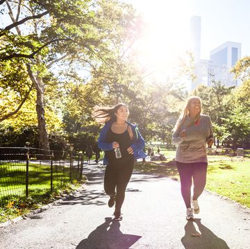 two plus size women jogging in central park, new york during a beautiful day